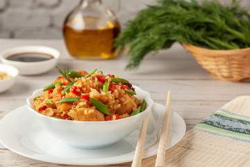Tori chahan fried Japanese rice with vegetables and chicken in soy sauce in a black plate on a wooden table © Nataliia Yudina