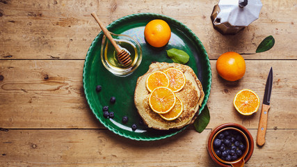 Stack of pancakes with blueberries and honey syrup.