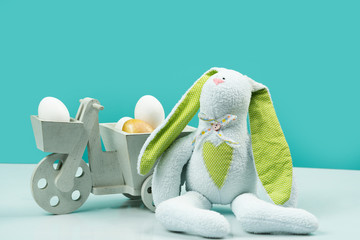Easter bunny with eggs on blue background. Happy easter. Soft bunny with easter eggs. Gift on...
