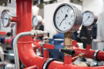 Close up of manometer, pipe, flow meter, water pumps and valves of heating system in a boiler room