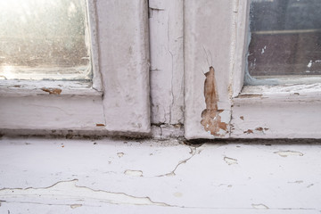 Old wooden window with peeling paint and durt needed to be repaired or replaced