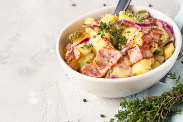 Traditional German potato salad with cucumber, onion and bacon prepared in Swabian-Style (Southern Germany). Kartoffelsalat.