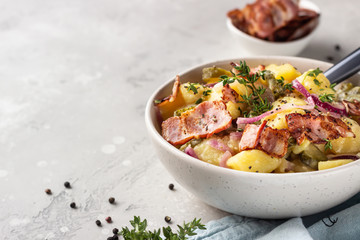 Traditional German potato salad with cucumber, onion and bacon prepared in Swabian-Style (Southern Germany). Kartoffelsalat.