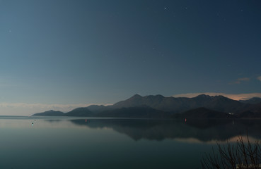 Fototapeta na wymiar Skadar lake with mountain range at night long exposure