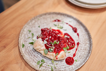 Fruit pizza. Pizza with raspberries, mascarpone and mint leaves. Traditional wood oven in restaurant, Italy. Original neapolitan pizza. Red hot coal.