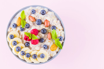 Healthy breakfast. Bowl of oatmeal porridge with fresh blueberries, raspberries, almonds and banana. Clean eating, dieting, detox, vegetarian food concept. Healthy lifestyle concept