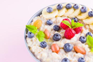 Healthy breakfast. Bowl of oatmeal porridge with fresh blueberries, raspberries, almonds and banana. Clean eating, dieting, detox, vegetarian food concept. Healthy lifestyle concept
