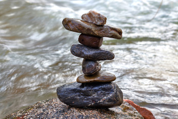 Fototapeta na wymiar Seven balanced stones in a river