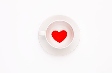 Top view of a white coffee Cup with a heart on a white background. Greeting card for Valentine's Day