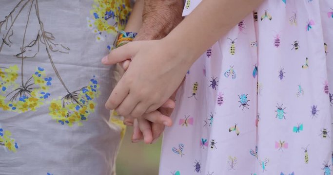 HELPING HAND. Detail of a Child's Hands Holding the Senior Woman Hands