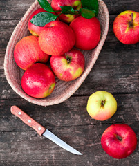 .apples in a basket on a wooden background with top