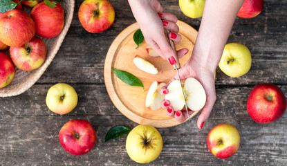 woman cuts an apple on a wooden board. cooking food. top view