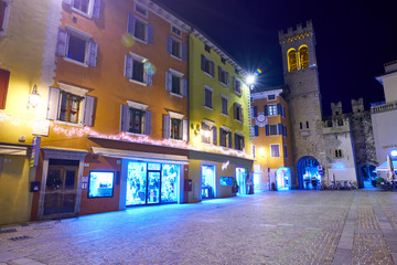Riva del Garda,Lago di Garda ,Italy - 10 December 2019:Christmas lights adorning the city center and Riva del Garda Street, View of the beautiful Riva del Garda town by night,Italy