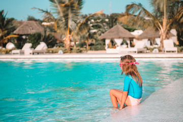 Obraz premium Adorable little girl swimming at outdoor swimming pool