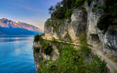 Fototapeta na wymiar Beautiful landscape. View of Lake Garda and the Ponale trail carved into the rock of the mountain , Riva del Garda,Italy. Popular destinations for travel in Europe