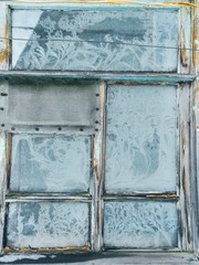 Frosty pattern on the window of an old house, similar to tree branches.