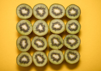 slices of kiwi on yellow background