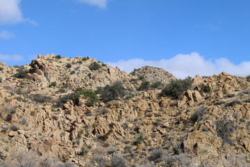 a blue sky and rocky hill ridge close-up