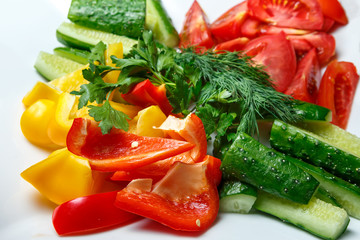 Sliced cucumbers, tomatoes, yellow and red peppers with dill