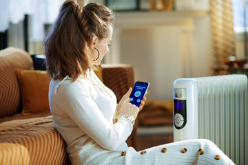woman and radiator using smartphone app for temperature control