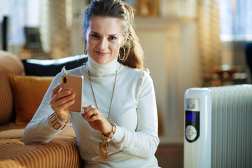 woman and radiator using smartphone app for temperature control