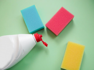 Set of housewives for washing dishes. Dishwasher. Bottle of washing utensils, sponges on background. Top view.