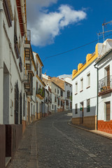 A small narrow street with white houses and blu sky in the old European city. Ronda, Andalusia, Spain.