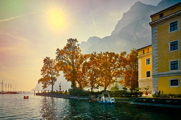 Tourists enjoying a walk around Lake Garda, colorful autumn in Riva del Garda surrounded by...