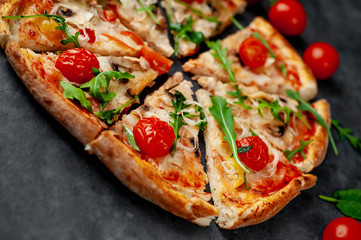 tasty italian pizza with mozzarella cheese, mushrooms, tomato, bell pepper, onion on a stone background