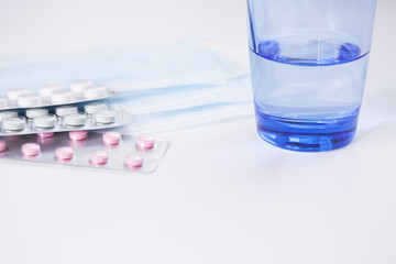 Medications pills drug, glass of water, mask and syringe. Flu outbreak and coronavirus or influenza. Medicine concept