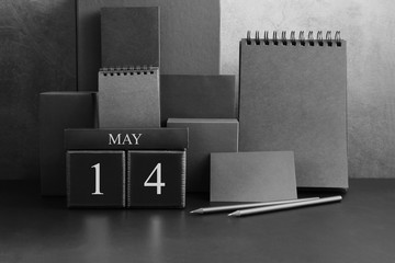 May 14th. Day 14 of month. Wood cube calendar with date month and day. Trendy classic black color. Lot of empty pages template for daily notes.