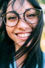 Nice girl with big eyes, long dark hair and pretty smile on the green background