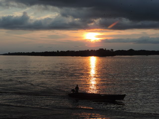 Fototapeta na wymiar canoe in ria in amazonia in the background the sunset