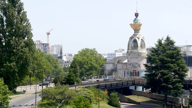 View of the city centre of Nantes, a city located in western France. There is greenery and an emblematic monument of the city, the LU Tower. Filmed in the summer, blue sky.