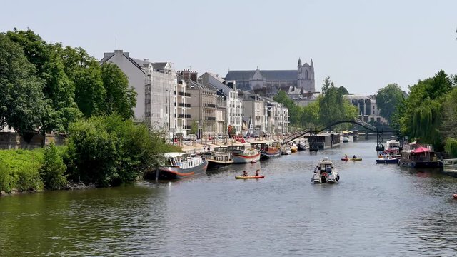Nantes is the capital of the Pays de la Loire Région in northwestern France, on the Loire River. View of the erdre river in Nantes, in the west of France. Boats on the water, filmed in summer.
