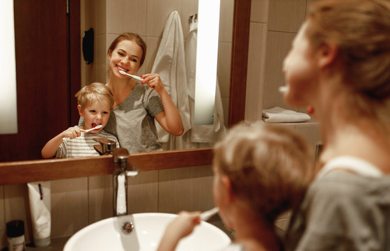 health and hygiene of the oral cavity. mother and child son brush their teeth in   bathroom in front of a mirror.