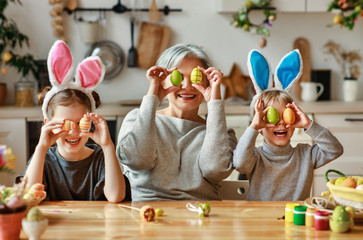Happy easter! family   grandmother and children grandchildren paint eggs for holiday.