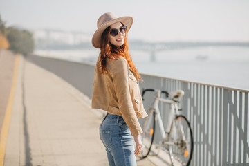 Shapely girl with red hair enjoying weekend in sunny morning. Photo of excited ginger lady in...