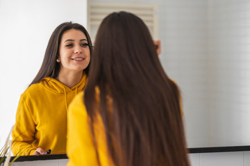 Mirror image of teenage girl applying mascara