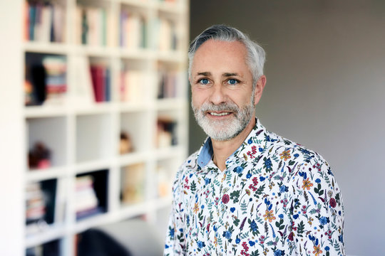 Portrait of mature man wearing patterned shirt at home