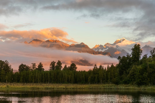 New Zealand, Westland District, Fox Glacier, Lake Matheson at dawn with mountains shrouded in fog in background - Powered by Adobe