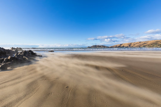 New Zealand, Blurred motion of waves brushing sandy coastal beach of Nugget Point