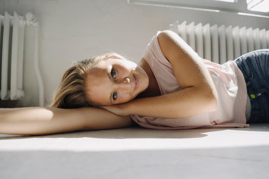 Portrait of blond young woman lying on the floor