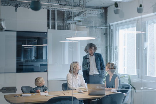 Business team with a boy having a meeting in office