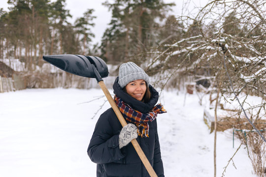 Portrait Of Smiling Woman With Snow Shovel