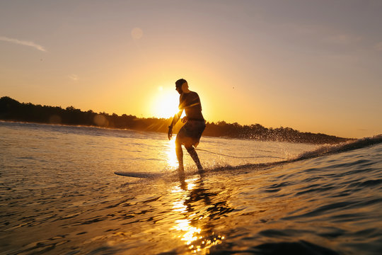Surfer at sunset, Bali, Indonesia