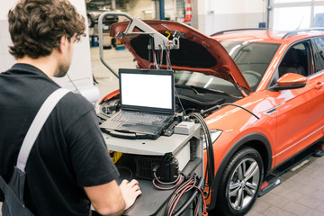 Car mechanic in a workshop using modern diagnostic equipment