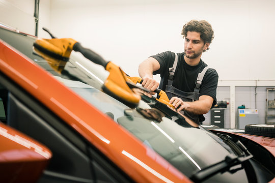 Car mechanic in a workshop changing car window