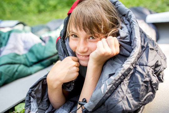 Smiling girl, wrapped in sleeping bag, portrait