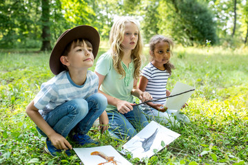 School children learning to distinguish animal species in forest